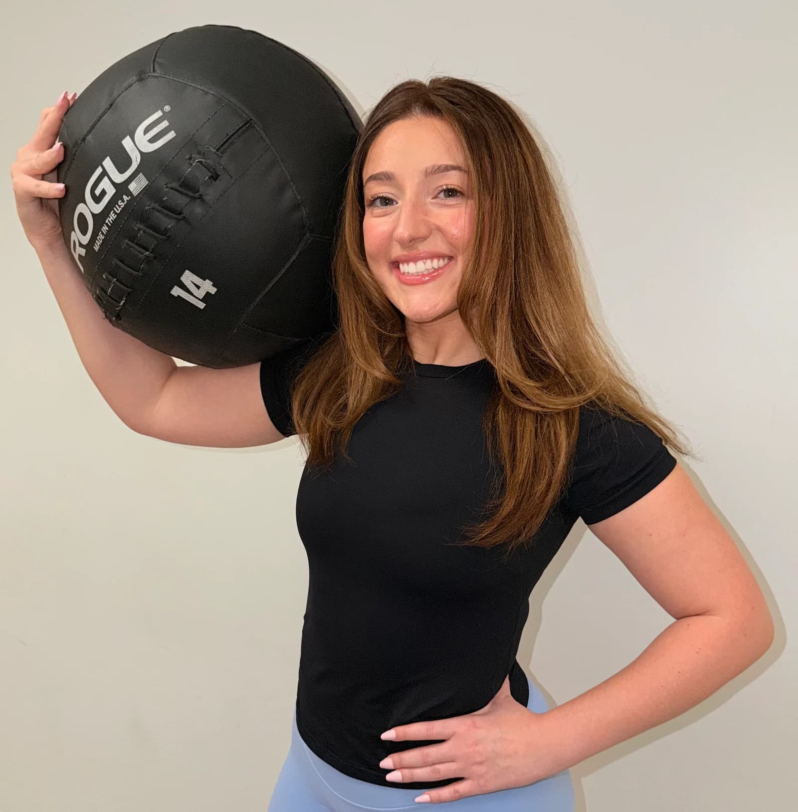 Shea smiling while holding a medicine ball